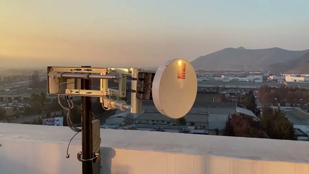 Posicionador remoto de antenas con una antena microondas instalado en una azotea, al atardecer